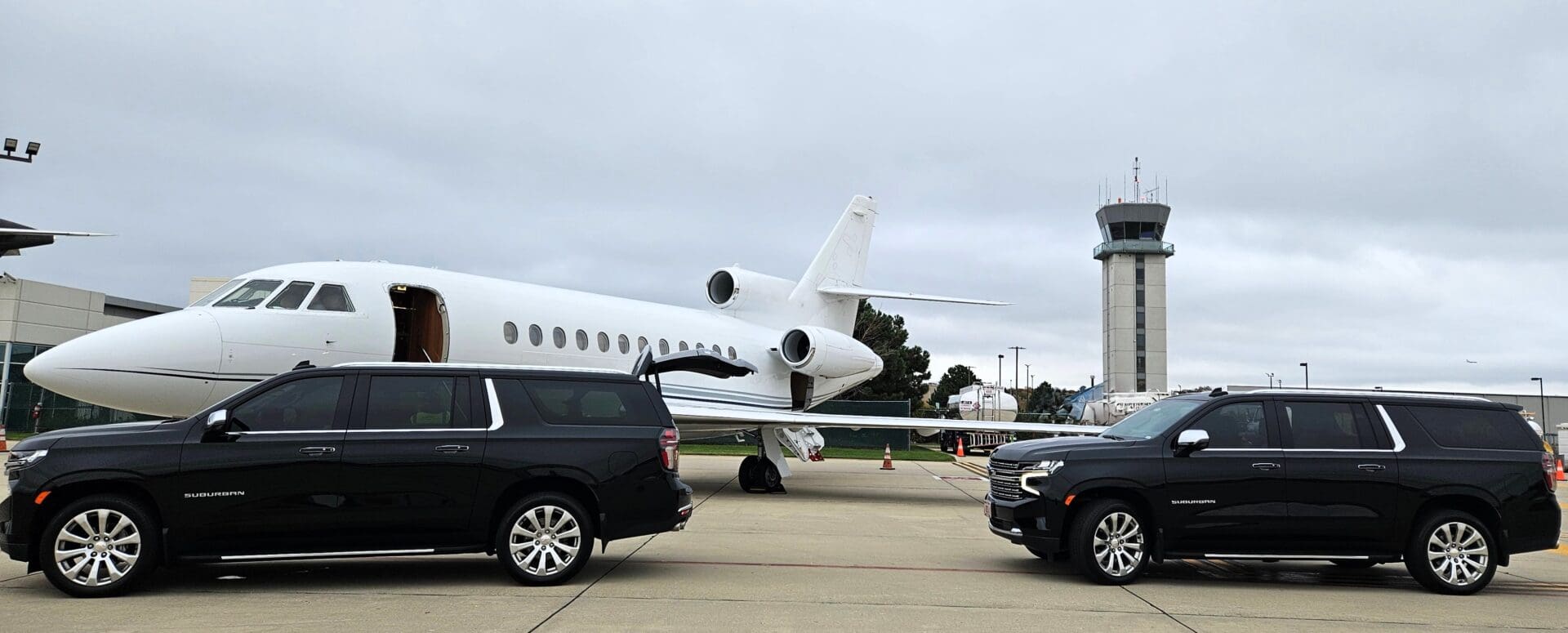 Ground transportation beside private jet and tower